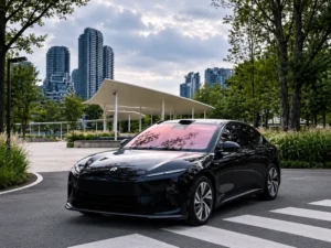 Dark sedan with a rose-tinted windshield in an urban park, illustrating rose-hue windshield protection film.
